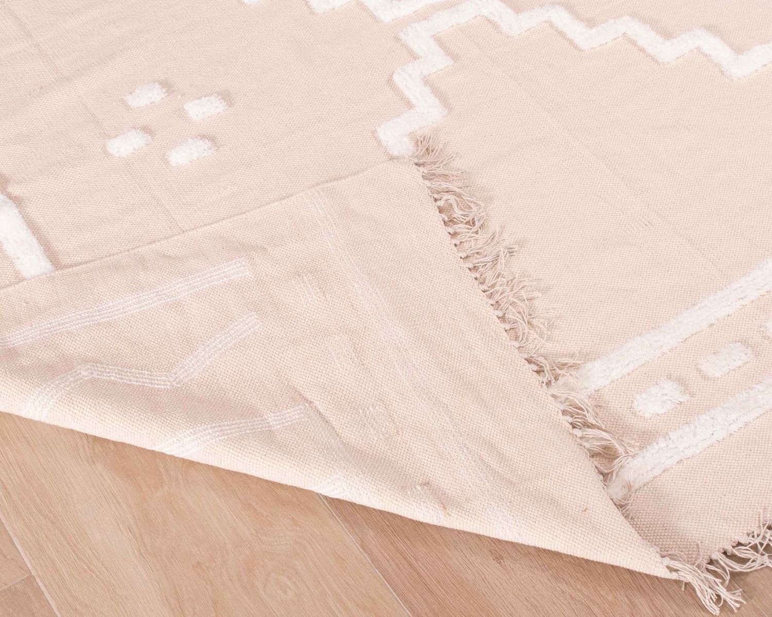 Tapis beige tissé main et motifs brodés blancs "Matis" format 120x180cm